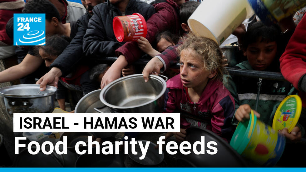 Palestinians with children wait to receive food cooked by a charity kitchen amid shortages of food supplies in Rafah, in the southern Gaza Strip, February 13, 2024.